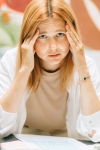 stressed woman with her hands on her face